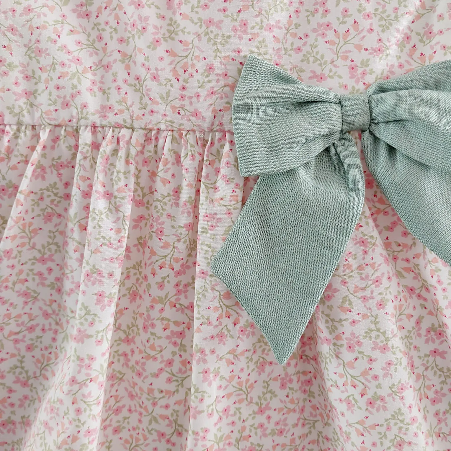 Jesusito Florecillas Mint Baby Fashion Verano 2025. Jesusito de talle alto sin mangas en color blanco con estampado de florecillas rosas y verdes.